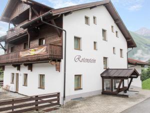 a large white building with a wooden roof at Chalet Rotenstein in Berwang