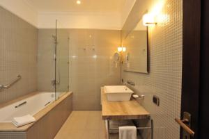 a bathroom with a tub and a sink and a bath tub at Hotel Casa Higueras in Valparaíso