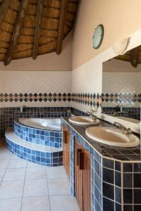 Kamanjab的住宿－Ondundu Lodge，浴室配有2个盥洗盆和1个浴缸。