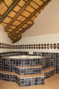 a bathroom with blue tiles and a tub at Ondundu Lodge in Kamanjab