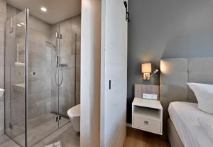 y baño con ducha, aseo y lavamanos. en Hotel- & Ferienanlage Kapitäns-Häuser Breege, en Breege