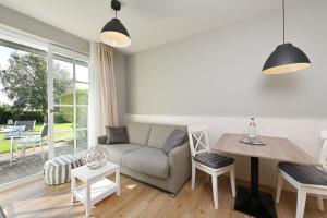 ein Wohnzimmer mit einem Sofa und einem Tisch in der Unterkunft Hotel- & Ferienanlage Kapitäns-Häuser Breege in Breege