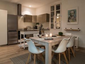 a kitchen with a wooden table and chairs and a kitchen with a counter at La Voile Bleue in Châteauneuf-du-Pape