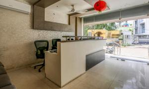 ein Büro mit einem Schreibtisch, Stühlen und einem Fenster in der Unterkunft Hotel Royal Elite Madurai in Madurai