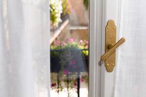 a wooden door handle on a window with flowers at Colle Ameno Room and Breakfast in Rovereto