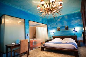 Dormitorio azul con cama y lámpara de araña en Anastazia Luxury Suites & Spa en Athens