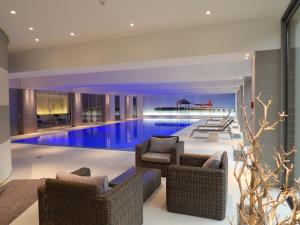 una grande piscina con mobili in vimini in una casa di Parc Hotel Alvisse a Lussemburgo