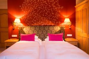 a bedroom with two beds with pink pillows at Alpenland - Das Feine Kleine in Lech am Arlberg