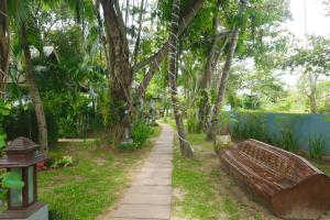 un parque con un banco y un sendero con árboles en Zara Beach Resort Koh Samui - SHA Extra Plus Certified, en Lamai