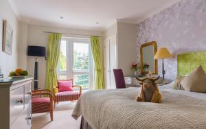 a stuffed animal sitting on a bed in a bedroom at The Airds Hotel and Restaurant in Port Appin