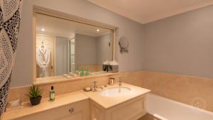 ein Badezimmer mit einem Waschbecken und einem großen Spiegel in der Unterkunft The Airds Hotel and Restaurant in Port Appin