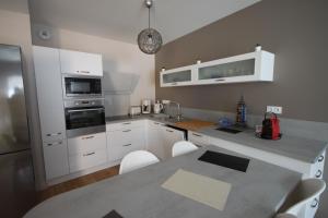 a kitchen with white appliances and a table with chairs at D5 - Résidence La Montille in Le Mont-Dore