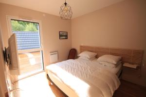 um quarto com uma cama e uma grande janela em D5 - Résidence La Montille em Le Mont-Dore