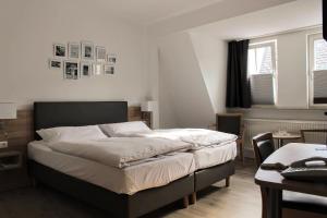 um quarto com uma cama grande e uma mesa em Hotel Zum Bären em Rüdesheim am Rhein