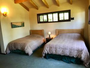 2 camas en una habitación con ventana en YAN KEE WAY LODGE BUNGALOW, en Puerto Varas