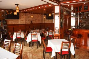 una sala da pranzo con tavoli e sedie bianchi di Hotel Wayra a Lima