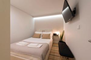 ポルトにあるLovelyStay - Porto Peaceful Living W/ Backyardの白い小さなベッドルーム(ベッド1台、薄型テレビ付)