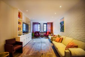 a living room with a yellow couch and a brick wall at Vakantiehuis Brickx in Koksijde