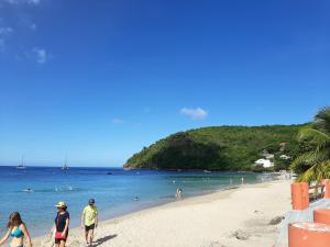 a group of people walking on the beach at Les Monts Arlésien in Les Anses-dʼArlets