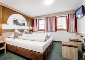 pokój hotelowy z łóżkiem i telewizorem w obiekcie Altes Holzhaus w Solden