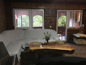 a living room with a white couch and a table at Kuca za odmor ,,Balkan” in Crni Vrh
