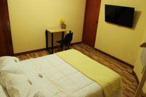 um quarto de hotel com uma cama e uma televisão em Hotel NUMAY em Cajamarca