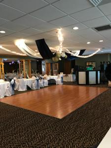 uma pista de dança num salão de banquetes com mesas brancas em Southgate Hotel em Cambridge