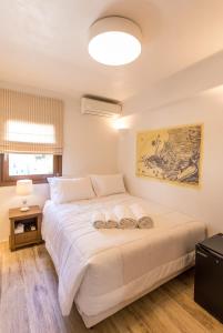 a bedroom with a large white bed in a room at Anagram Hotel in M&yacute;konos City