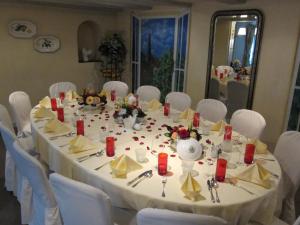 a long table with white chairs and a white table cloth at Landhotel Hirschen in Trüllikon