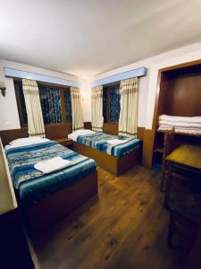 a hotel room with two beds and a desk at Souvenir Guest House in Kathmandu