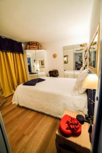 1 dormitorio con 1 cama grande y una mesa con sombrero rojo en Diodato Suite Apartment - Amazing Location, WiFi, Pool, Sauna, Gym & Private Garden, en Roquebrune-Cap-Martin