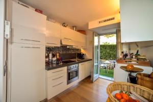 una cocina con armarios blancos y una mesa con naranjas en Diodato Suite Apartment - Amazing Location, WiFi, Pool, Sauna, Gym & Private Garden, en Roquebrune-Cap-Martin