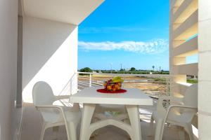 a white table and chairs on a balcony with a cake at Le Dimore di Otranto in Otranto