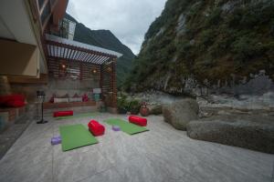 una habitación con alfombras verdes en el suelo junto a una montaña en Casa del Sol Machupicchu, en Machu Picchu