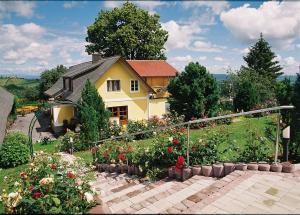 a house with a flower garden in front of it at Weingut Lambauer in Kitzeck im Sausal