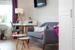 a living room with a couch and a table at Landhotel Rosenschänke in Kreischa