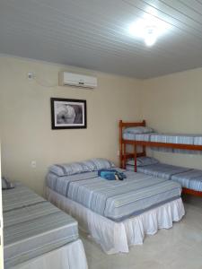 a room with three beds in a room at Cantinho Dom Inácio in São Gabriel