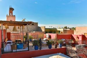 a balcony with potted plants on top of a building at Riad Rose Meryam in Marrakesh