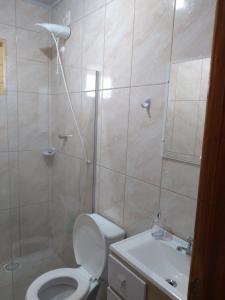 a bathroom with a toilet and a shower and a sink at Cantinho Dom Inácio in São Gabriel
