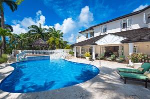 a swimming pool in front of a house at Seventh Heaven by Island Villas in Saint James