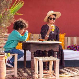 een vrouw en een kind aan een tafel bij Riad Rose Meryam in Marrakesh