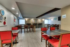 une salle à manger avec des tables en bois et des chaises rouges dans l'établissement Holiday Inn Express Pittston - Scranton Airport, an IHG Hotel, à Pittston