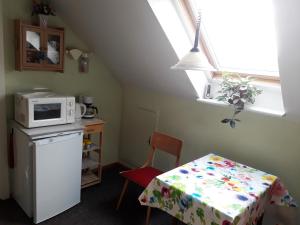 a small kitchen with a table and a microwave at Das besondere Quartier in Berlin - Pankow in Berlin
