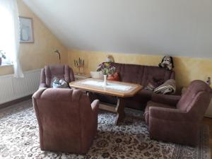 een woonkamer met een bank, 2 stoelen en een tafel bij Das besondere Quartier in Berlin - Pankow in Berlijn