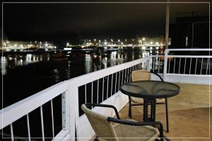 Hotel Náutico de Paita في Paita: طاولة وكراسي يجلسون على شرفة في الليل