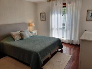 1 dormitorio con cama y ventana grande en Apartment Afonso Henriques, en Coímbra