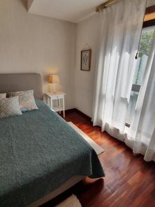 een slaapkamer met een bed en een groot raam bij Apartment Afonso Henriques in Coimbra