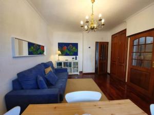 a living room with a blue couch and a table at Apartment Afonso Henriques in Coimbra