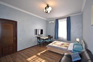 Schlafzimmer mit einem Bett, einem Tisch und einem Fenster in der Unterkunft Apartment near Sasundci Davit Metro Station in Yerevan