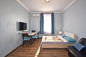 a bedroom with a bed and a table with chairs at Apartment near Sasundci Davit Metro Station in Yerevan